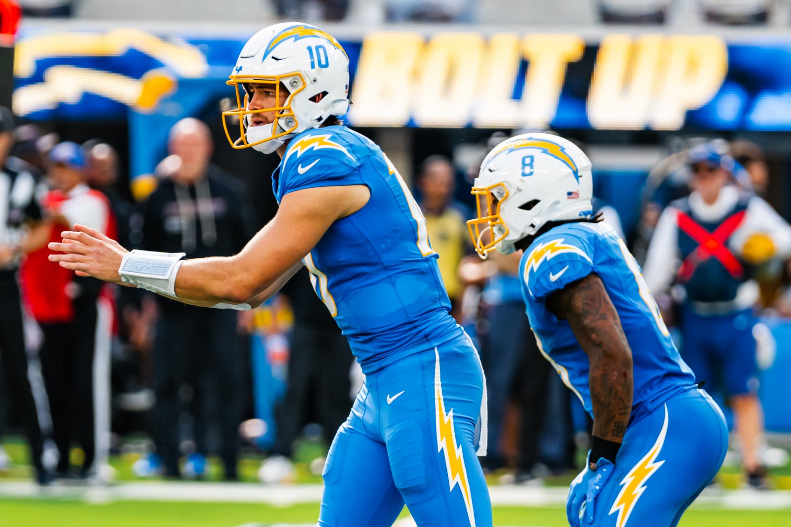 Justin Herbert and Omarion Hampton of the Los Angeles Chargers on the field against the Washington Commanders, October 2025